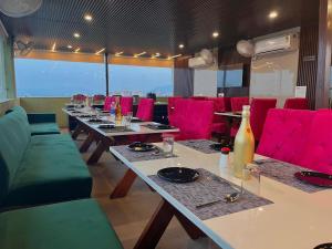 un restaurant avec de longues tables et des chaises rouges lumineuses dans l'établissement Hotel La Casa Amritsar Near ISBT & Golden Temple, à Amritsar