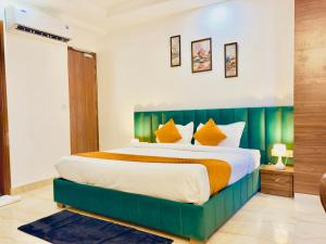 a bedroom with a large bed with a green headboard at Hotel La Casa Amritsar Near ISBT & Golden Temple in Amritsar