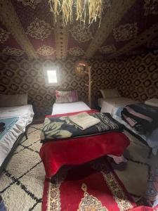 a bedroom with two beds in a room with a ceiling at Mustapha Camp Merzouga in Merzouga