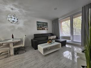 a living room with a black couch and a table at Apartmány Urban in Poprad