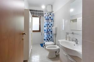 Baño blanco con aseo y lavamanos en Casa Vacanza Violisa, en Alcamo Marina