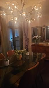 een kamer met een tafel, een spiegel en een kroonluchter bij Legacy Hotel - Sandton City in Johannesburg