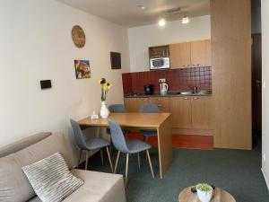 a living room with a table and a kitchen at Apartmán PalacKY in Kyjov