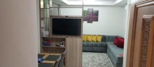 a living room with a couch and a flat screen tv at Adan Beach appartment in front of Atlantic in Aourir