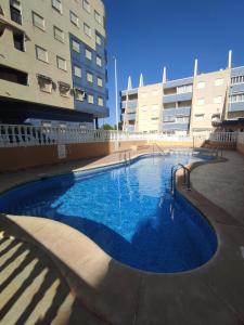 a large swimming pool in front of two tall buildings at Sandy Home - Élvezd a tengerpartot! in La Mata