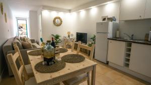 una cucina e un soggiorno con tavolo e frigorifero di Ocean Beach House a Torres Vedras