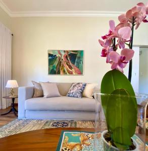 a living room with a couch and a vase with flowers at Rondeletia Cottage Guesthouse - premium self catering in Winston Park