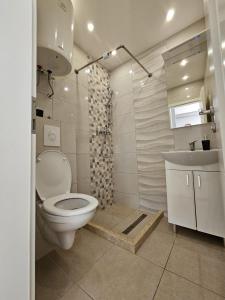 a white bathroom with a toilet and a sink at Apartment Vesna in Podaca +125 photos