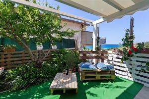 un patio con mesa y vistas al océano en Casa Vacanza Violisa, en Alcamo Marina