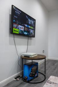 a flat screen tv hanging on a wall at Modern and Comfy in City Centre PS4 , Free On Street Parking ,Walking Distance To Bus, Train Stations And Shopping Centres in Leicester