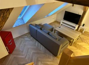 Una sala de estar con un sofá azul y un televisor. en Exklusive Maisonetten Wohnung mit Gartenzugang, en Augsburg