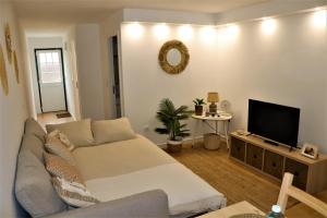 un soggiorno con divano e TV a schermo piatto di Ocean Beach House a Torres Vedras