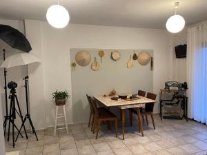 a dining room with a table and chairs and a camera at Full of Cretan Nature Apartment in Stavrákia +13 photos