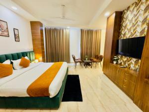 a hotel room with a bed and a flat screen tv at Hotel The Casa Hamilton, City Centre Amritsar in Amritsar
