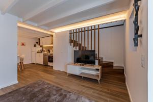 een woonkamer met een televisie en een trap bij Douro View Charming Apartment Duplex in Valbom
