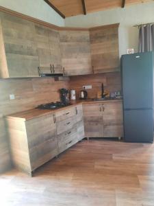 a kitchen with wooden cabinets and a refrigerator at Light house Dilijan in Dilijan