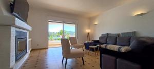 een woonkamer met een bank en een open haard bij Superbe Villa - piscine privée in Silves