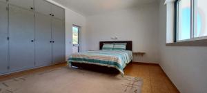 een witte slaapkamer met een bed en een raam bij Superbe Villa - piscine privée in Silves +46 foto's