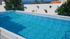 a swimming pool with blue water in a backyard at La Casa de Teror in Teror