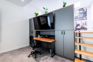 an office with a desk and a tv on a wall at Wohnen im ehemaligen Schießstand in Cologne