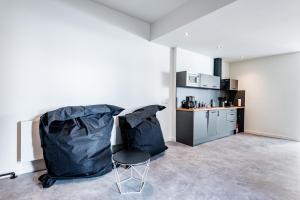 a living room with a chair and a kitchen at Wohnen im ehemaligen Schießstand in Cologne