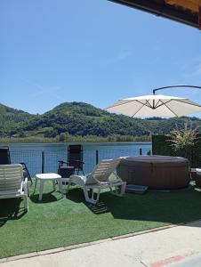 a patio with a hot tub and chairs and an umbrella at Kuća za odmor Drina in Zvornik