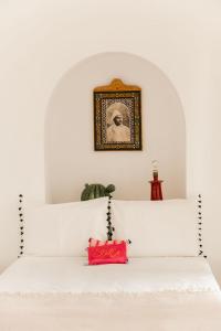 - une chambre dotée d'un lit blanc avec une photo sur le mur dans l'établissement Riad La Lumière d'Étoile, à Marrakech