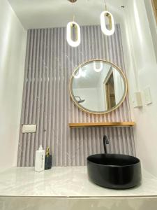 a bathroom with a black sink and a mirror at Grace Residences Elevate Escapes in Manila
