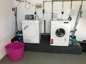 a laundry room with a washing machine and a bucket at Gästehaus Nicole in Burgau