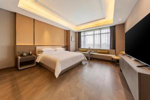 um quarto com uma cama e uma televisão de ecrã plano em Jiangshan Yunfan Sports Resort Hotel em Jiangshan