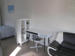 Zimmer mit einem Schreibtisch, einem Bett und einem Stuhl in der Unterkunft Petite maison au calme in Telgruc-sur-Mer