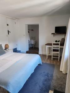 a bedroom with a large bed and a desk at Bed and Breakfast Les Airelles in Val-des-Prés