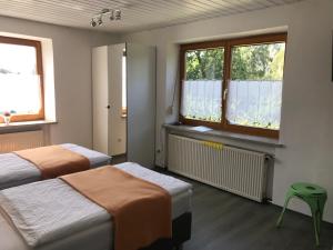 twee bedden in een kamer met twee ramen bij Gästehaus Nicole in Burgau