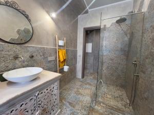 La salle de bains est pourvue d'un lavabo et d'une douche en verre. dans l'établissement RADICI, à Agerola