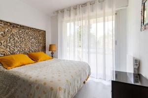 a bedroom with a large bed and a large window at Appartement Lumineux avec parking privé à proximité de la Plage Benoît de La Baule in La Baule