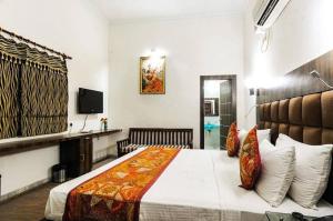 Hotel Urban Zip في آغْرا: غرفة نوم فيها سرير وتلفزيون