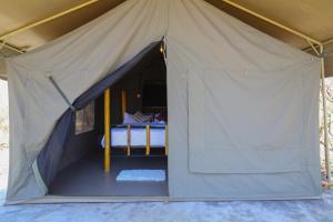 a tent with a bed inside of it at Emunyan maasai Mara camp in Sekenani