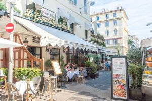 pessoas sentadas em mesas fora de um restaurante em uma rua em 50 meters from the beach ! Best location in Nice em Nice