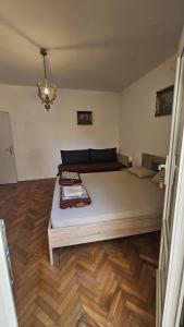 a bedroom with a large bed with a wooden floor at Radenović, soba in Budva