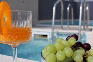 a glass of wine next to a bowl of grapes at Villa Melassy in Makarska +120 photos