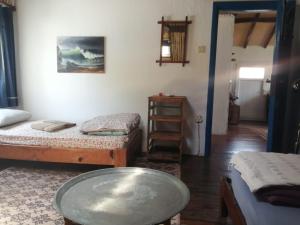 a room with two beds and a table in it at Ecer Pansiyon in Kuşadası