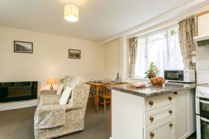 a kitchen and living room with a couch and a table at April Cottage in Minehead