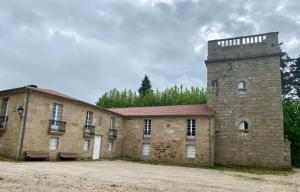 an old brick building with a tower on top at APARTAMENTO CASA PLAYA in Boiro