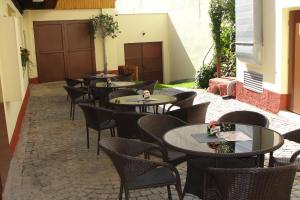 rzędu stołów i krzeseł na dziedzińcu w obiekcie Hotel Panský dům w mieście Nové Město na Moravě