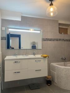a bathroom with a sink and a mirror and a tub at REZ de jardin moderne 4 chambres 8 personnes jardinet in Bagnols-sur-Cèze +55 photos