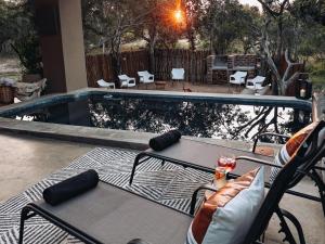 a patio with a table and chairs next to a swimming pool at Rhino's Rest Luxury Villa in Hoedspruit