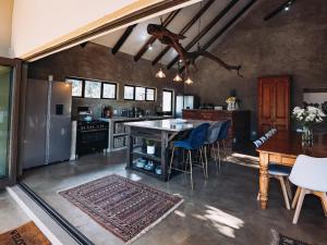 - une cuisine avec une table, des chaises et un comptoir dans l'établissement Rhino's Rest Luxury Villa, à Hoedspruit
