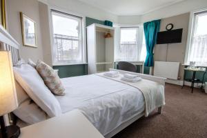 1 cama blanca grande en una habitación con ventanas en The Kings Arms en Londres