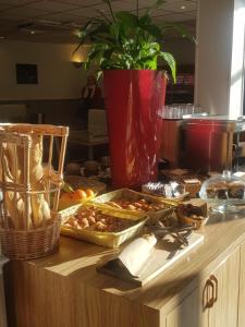 a buffet with a tray of food on a table at KYRIAD ORANGE Centre Ville - HOTEL RESTAURANT BAR - Galerie d'Art des Princes - Provence Alpes Côte'Azur - France - AUTOROUTE A7-A9 - exit21- Châteauneuf-du-Pape Avignon Bollene Nimes Valence - Terrasse - Repas - Petit Déjeuner in Orange