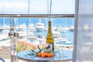 una mesa con una botella de vino y copas de vino en Galatia Studios and Apartments, en Benitses